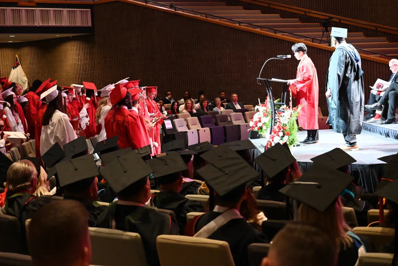 Student speaking to audience at graduation ceremony.
