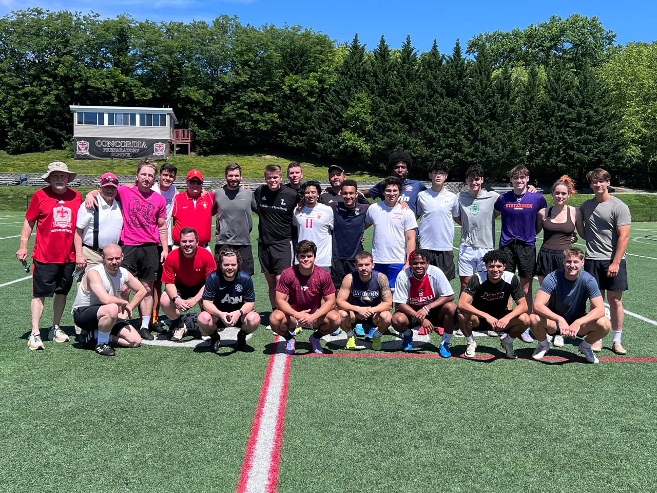 Alumni and coaches posing for photo at the alumni soccer game