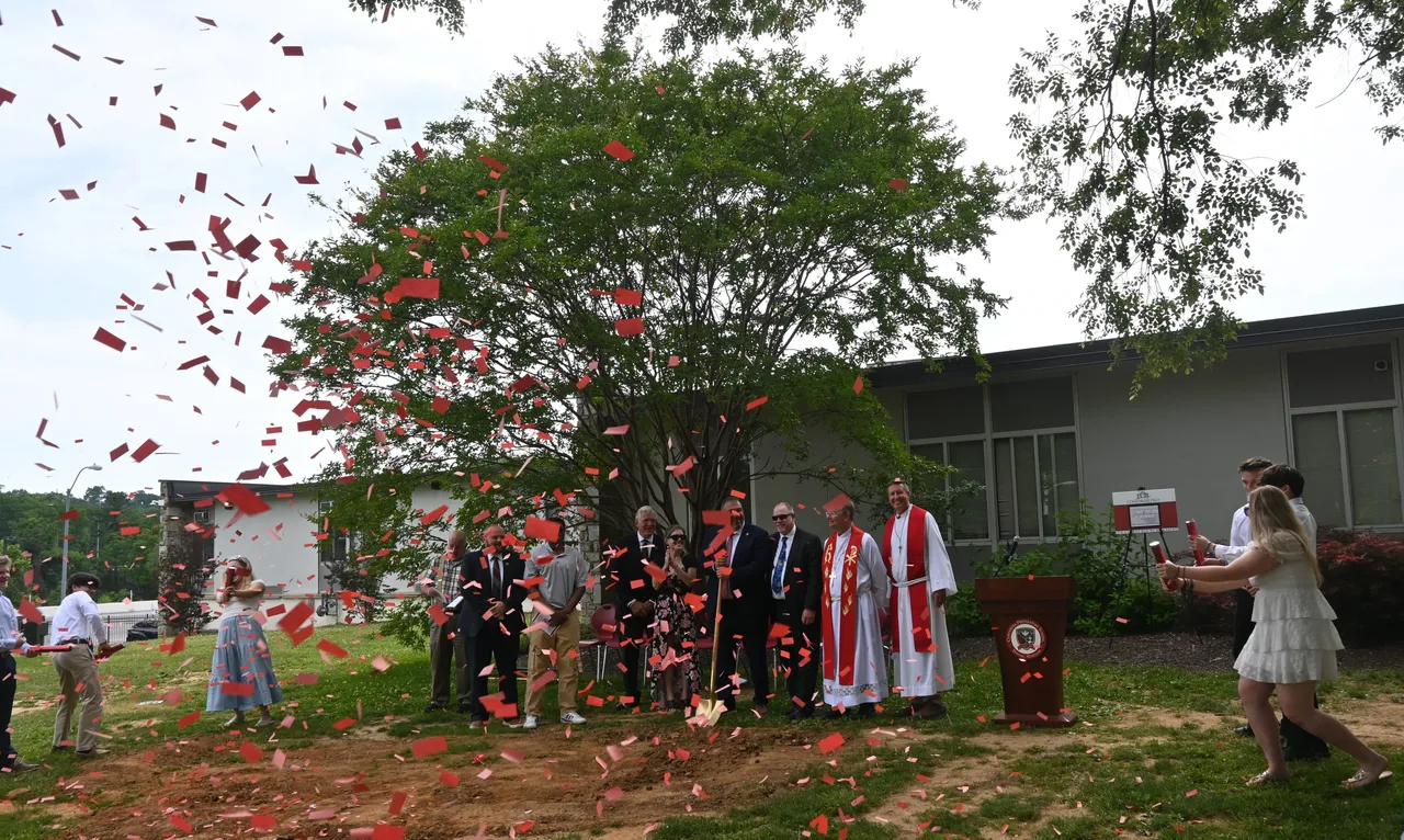 Students, alumni, faculty, and supporters of the school celebrating the groundbreaking ceremony for a new classroom wing.