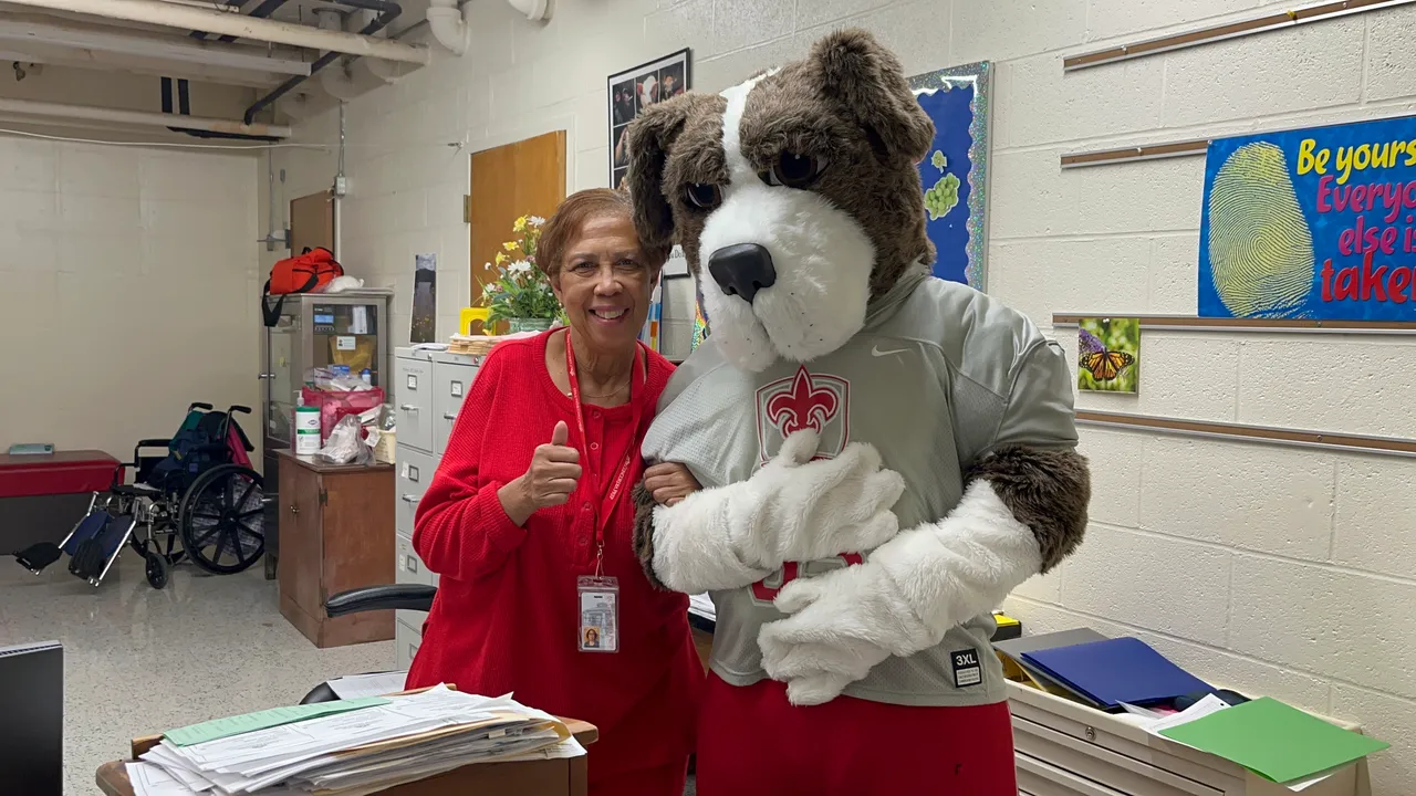 The School Nurse poses with Luther the Saint Bernard mascot in the Nurse's Office.