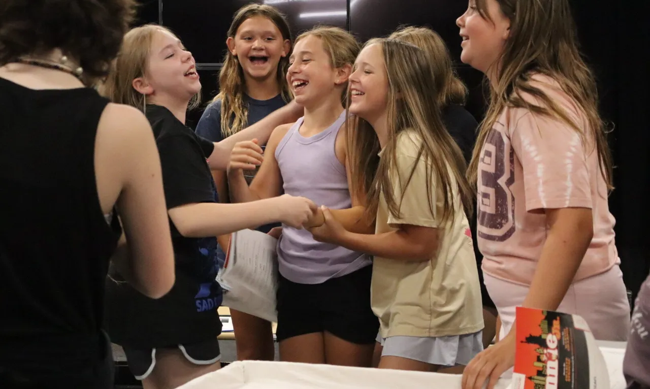 A group of campers smiling during theatre camp.