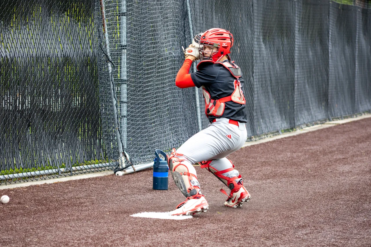 Jonathan Couser '26 wearing catcher's gear and throwing the baseball