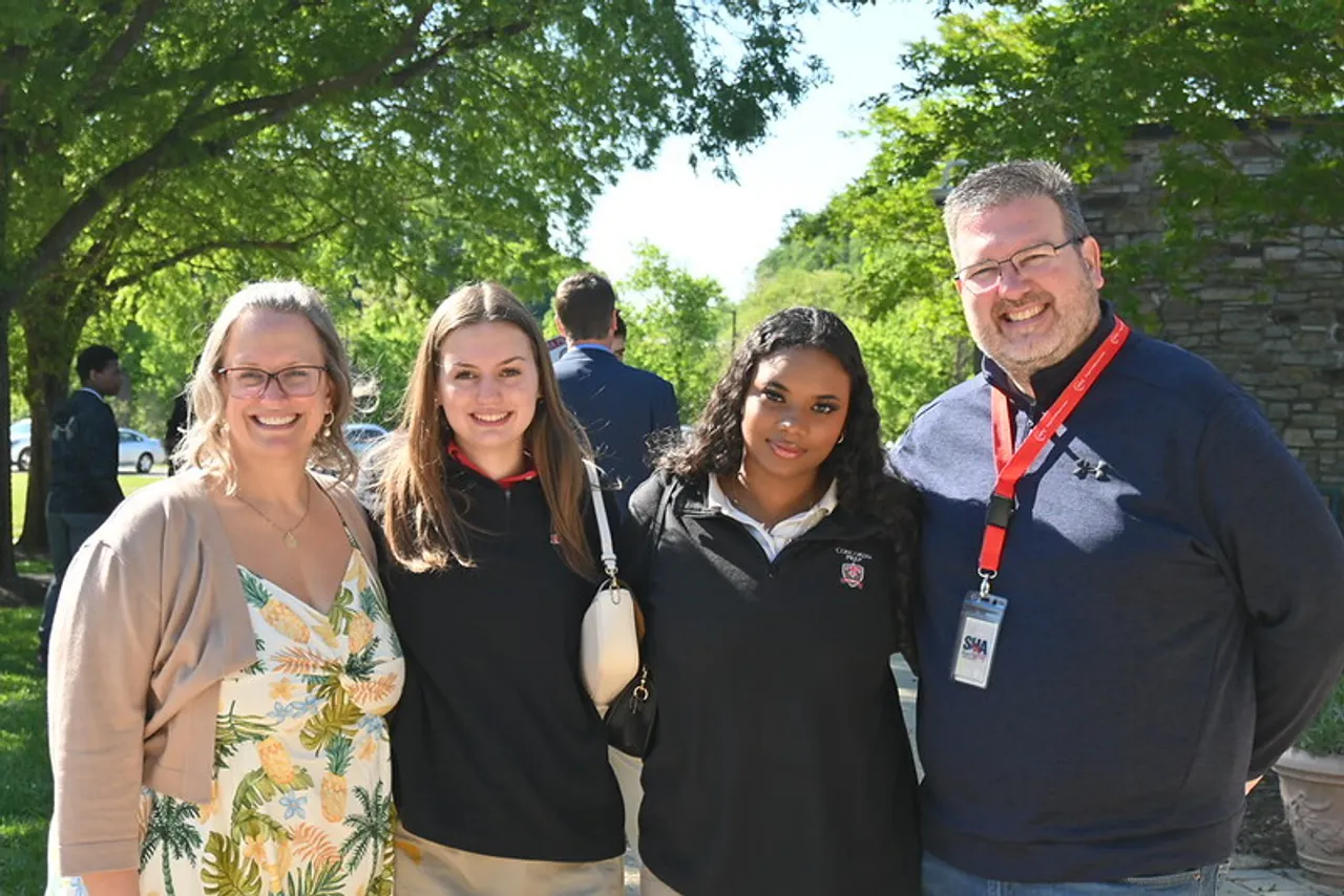 Members of a Saints family smiling outside the School