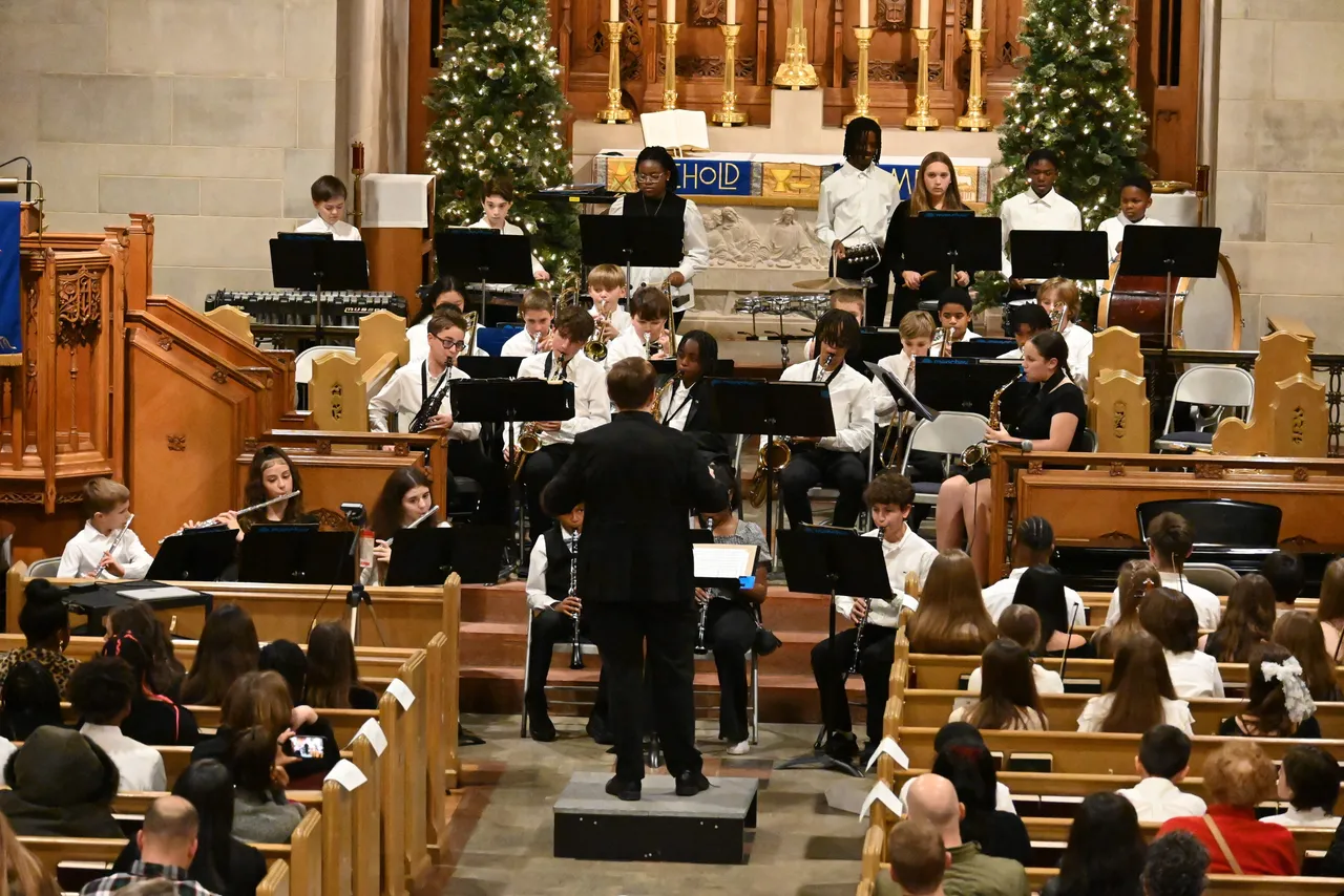 Members of the Concordia Prep band and orchestra playing instruments in a church