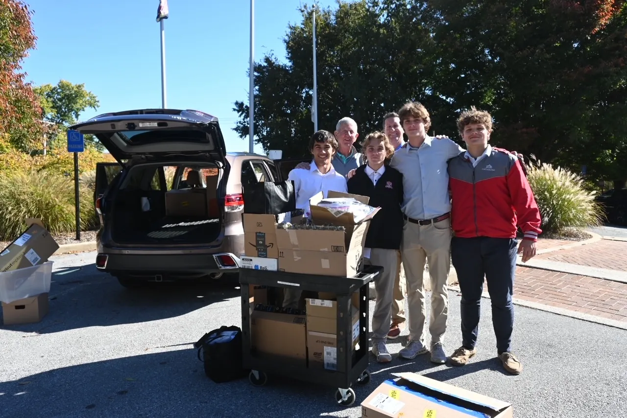 Students pose after loading car with donations.