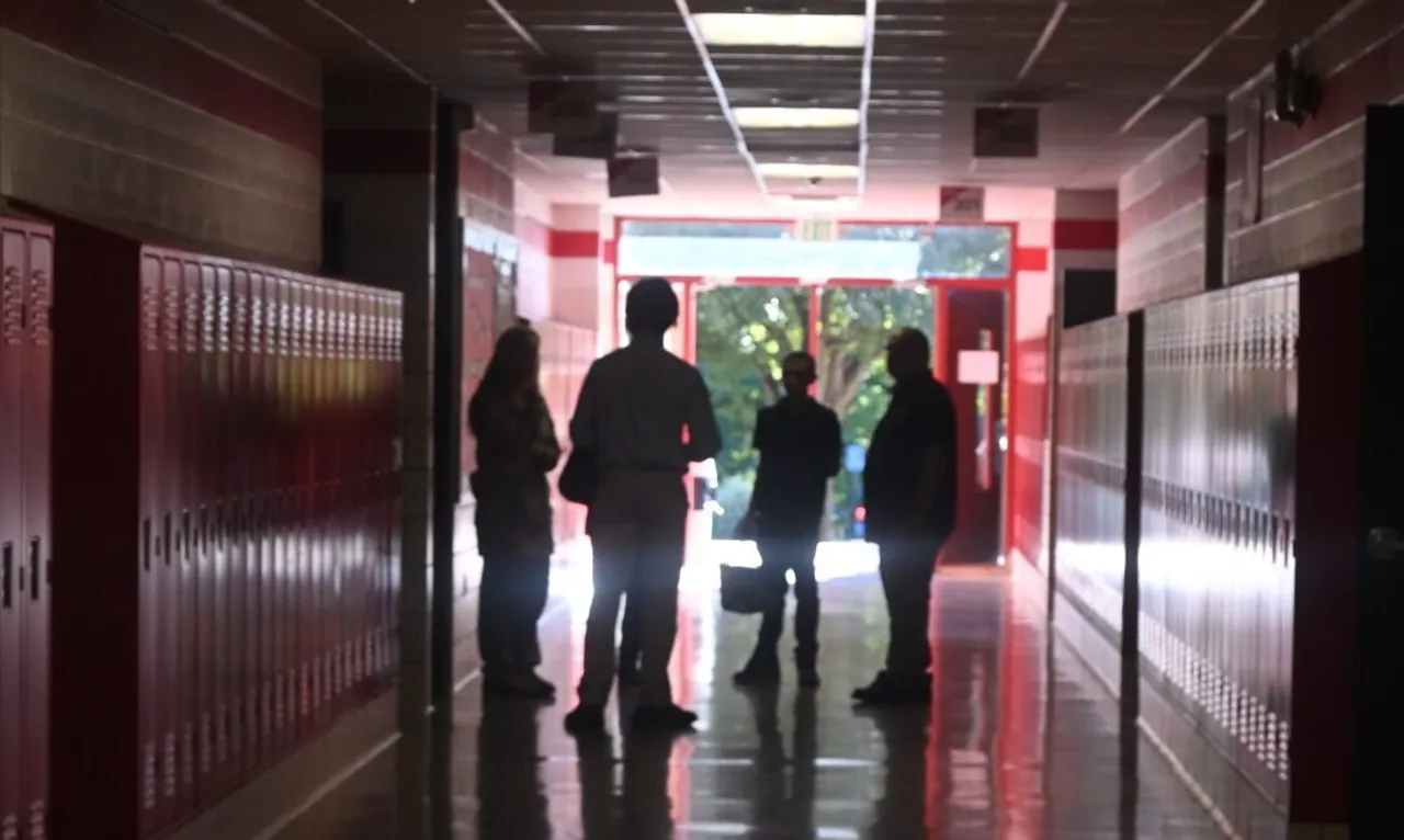 Four people standing in the school hallways