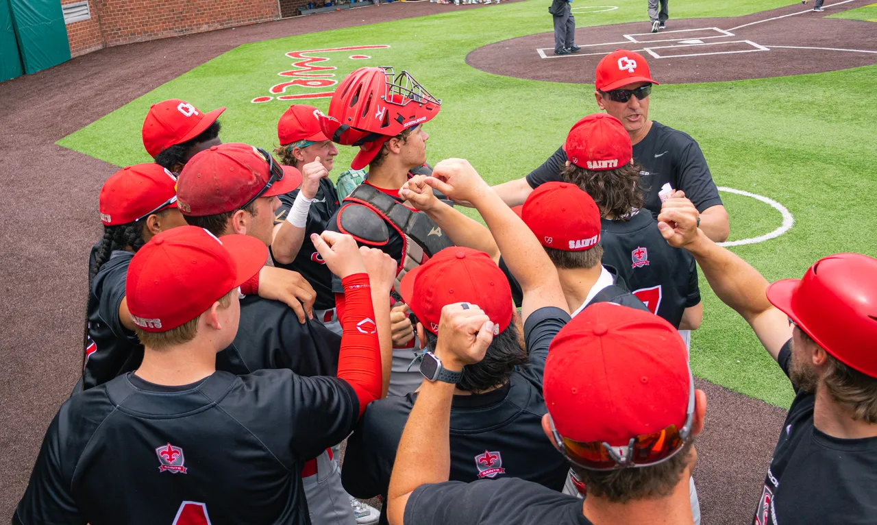 Student athletes on baseball team gathered in huddle before the game.