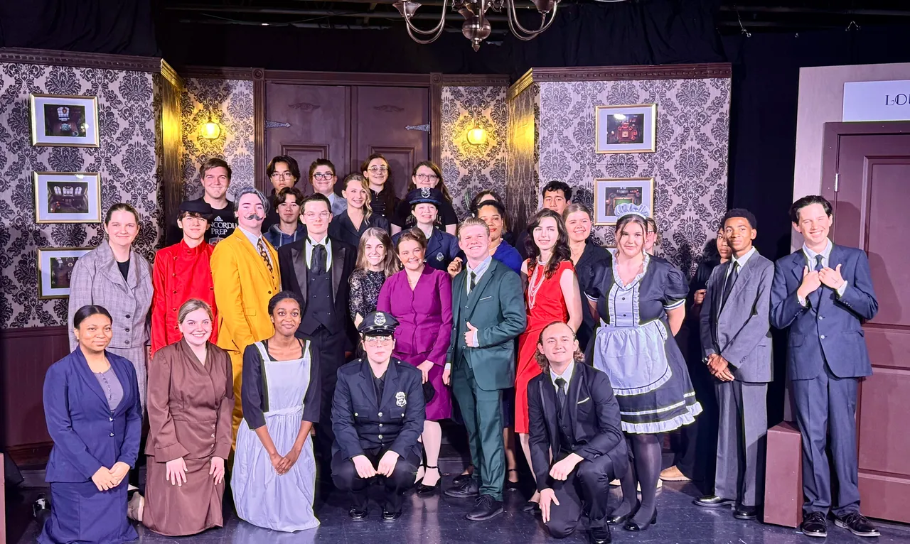Students pose in character in the Black Box Theatre before a performance.
