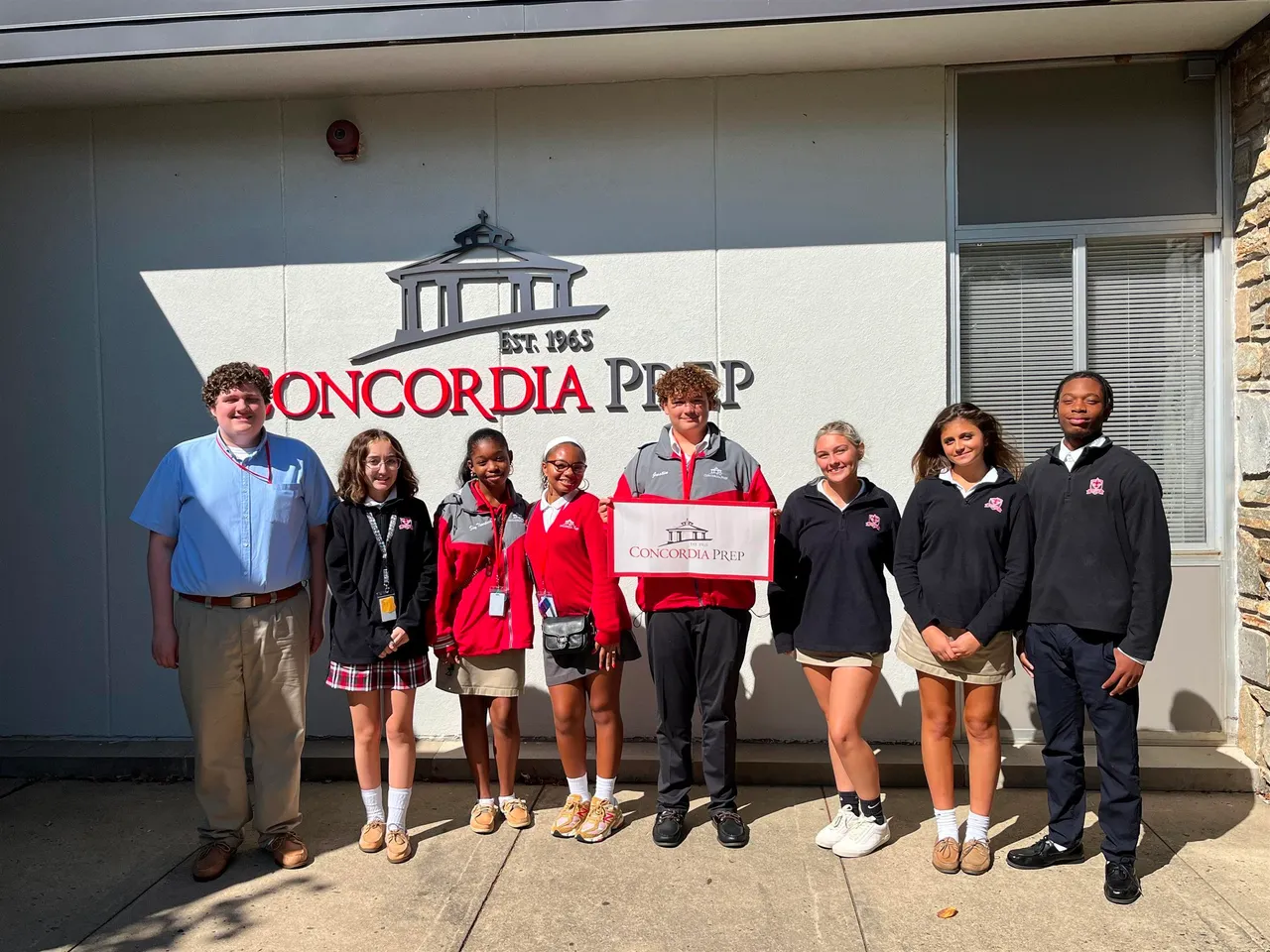 Flaherty Foundation Scholars posing for photo by the School sign