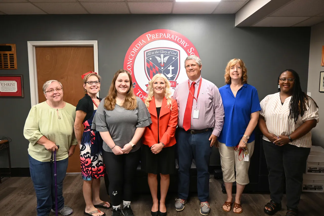 Faculty who are also alumni pose for photo at beginning of school year.