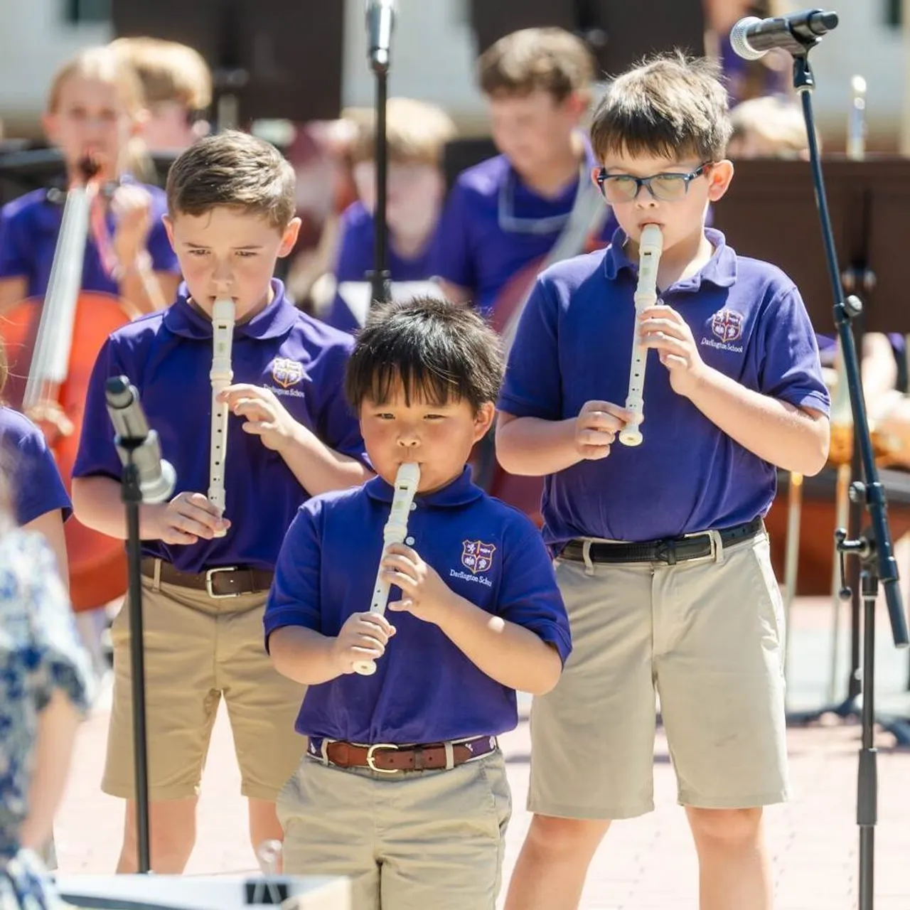 Lower grades students play instruments at a band concert outdoors