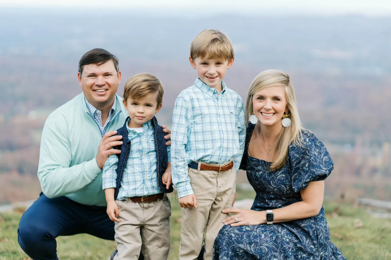Female alumna pictured with her family outdoors.