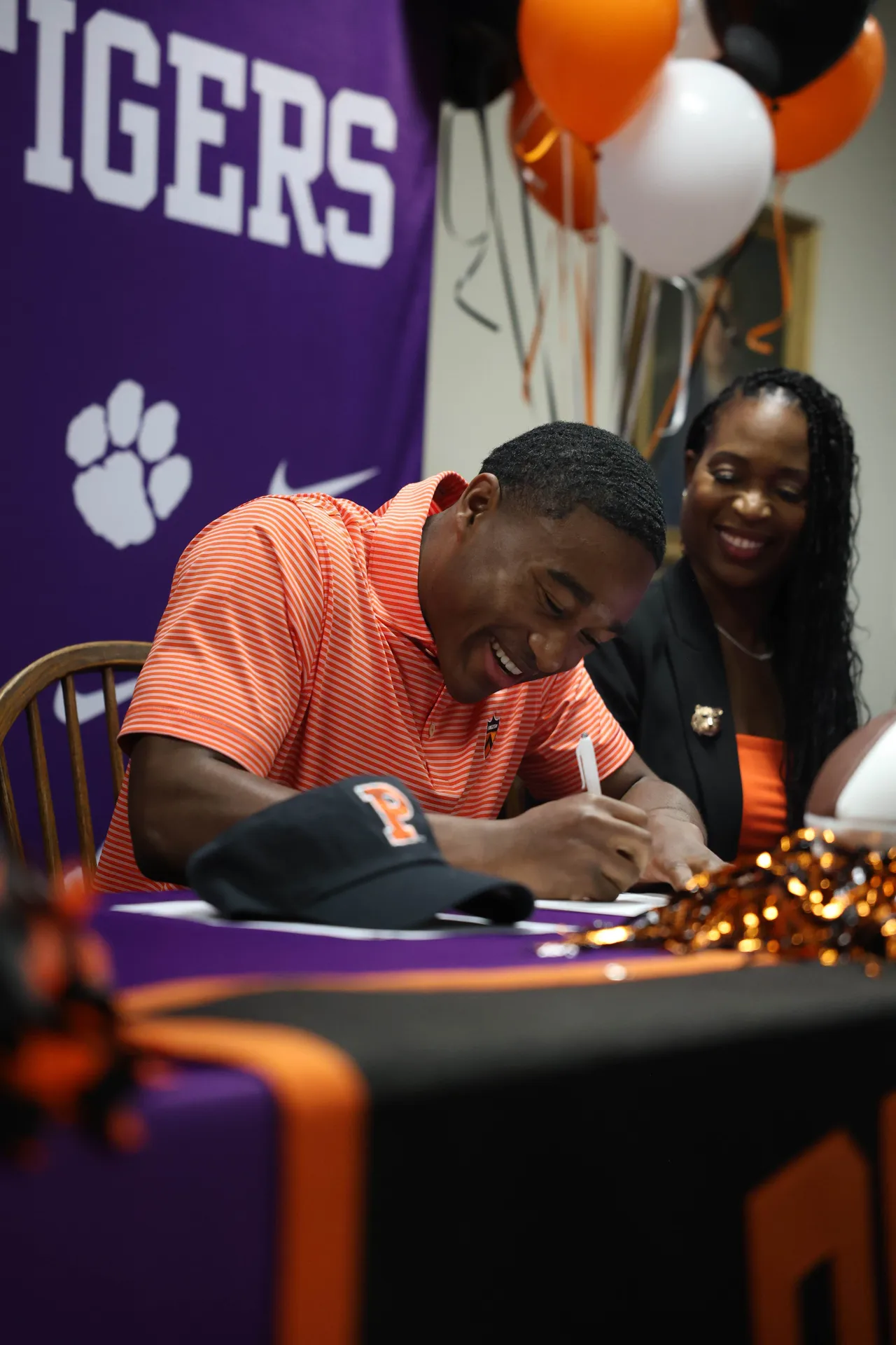 Male student signs his letter of intent to play football at Princeton University.
