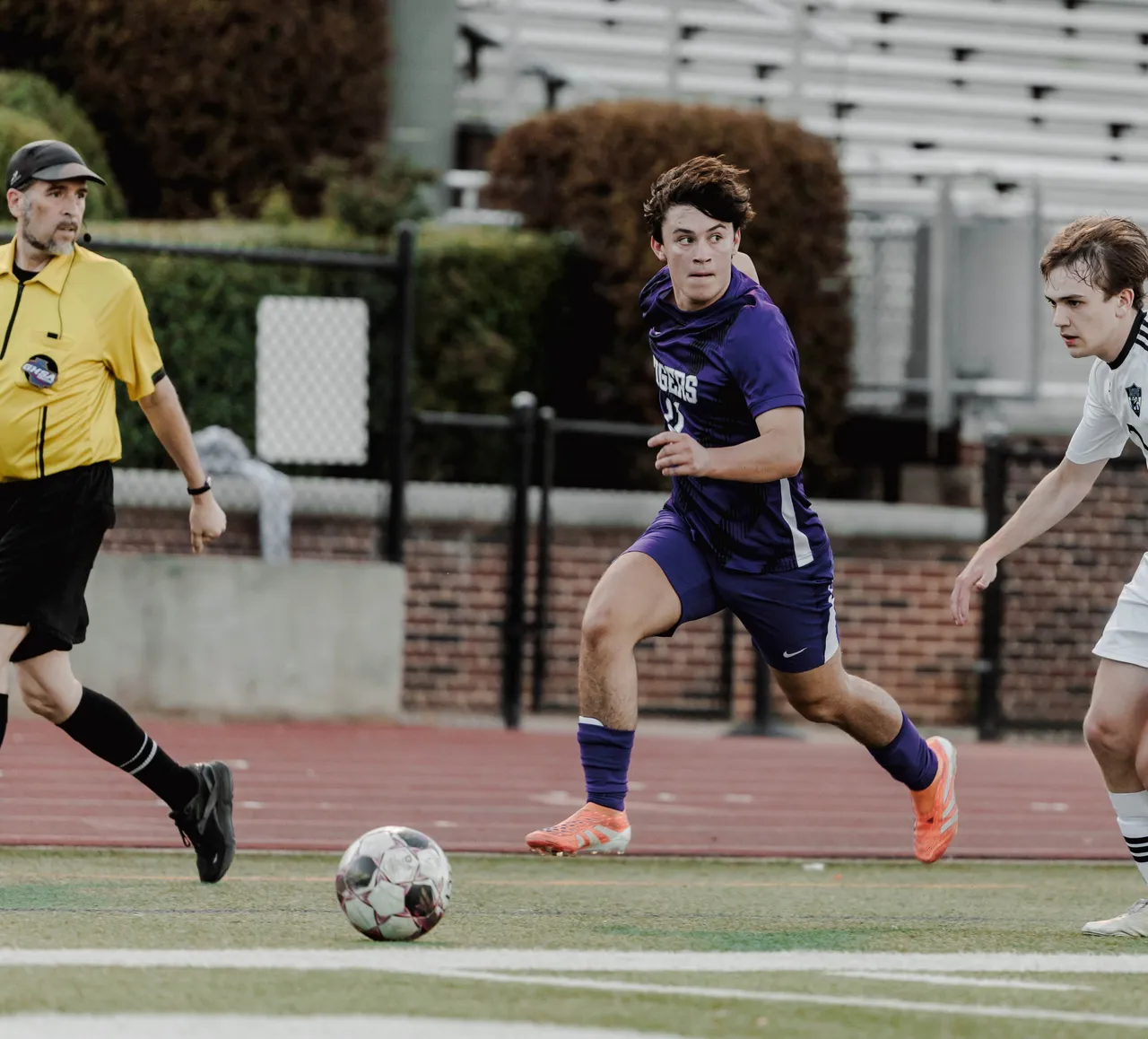 Male soccer player runs down the field and prepares to kick the ball