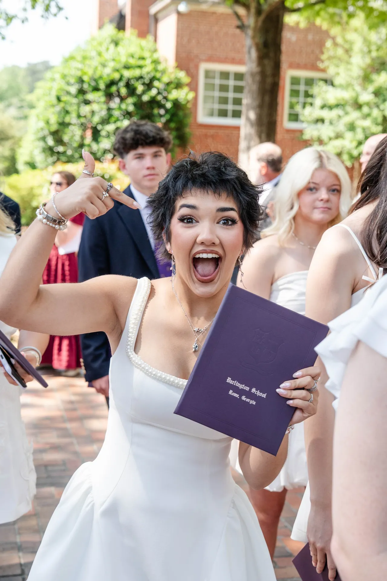 Female high school student shows off her diploma after graduating from Darlington School