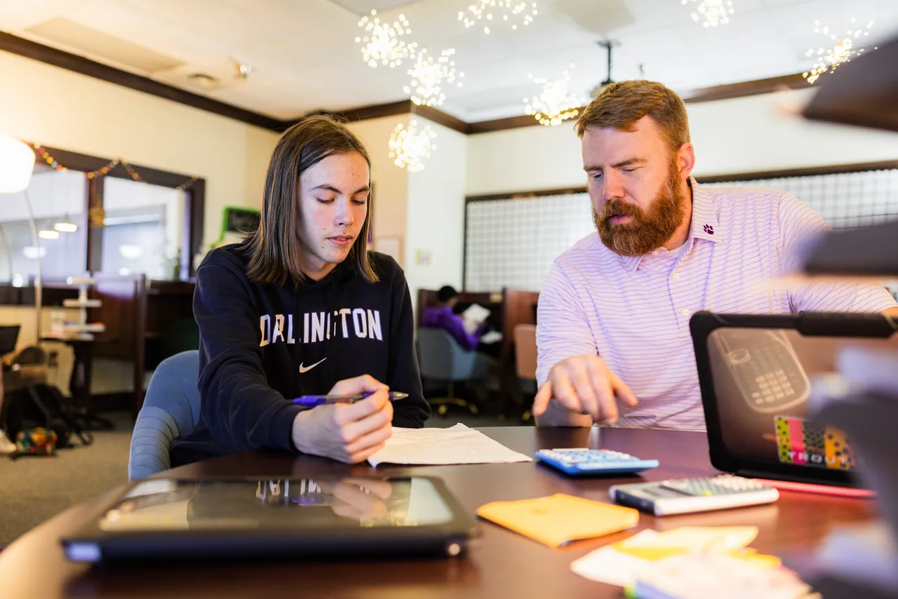 Male learning specialist works with a male high school student in the Teaching and Learning Center on learning strategies