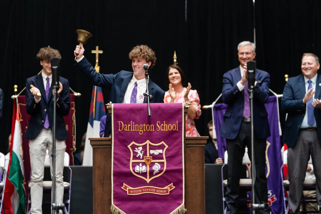 Male student body president rings the ceremonial bell during Darlington School's Opening Convocation.