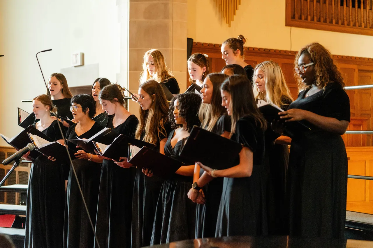 Female high school students who are members of the Concert Choir sing during a concert in the chapel