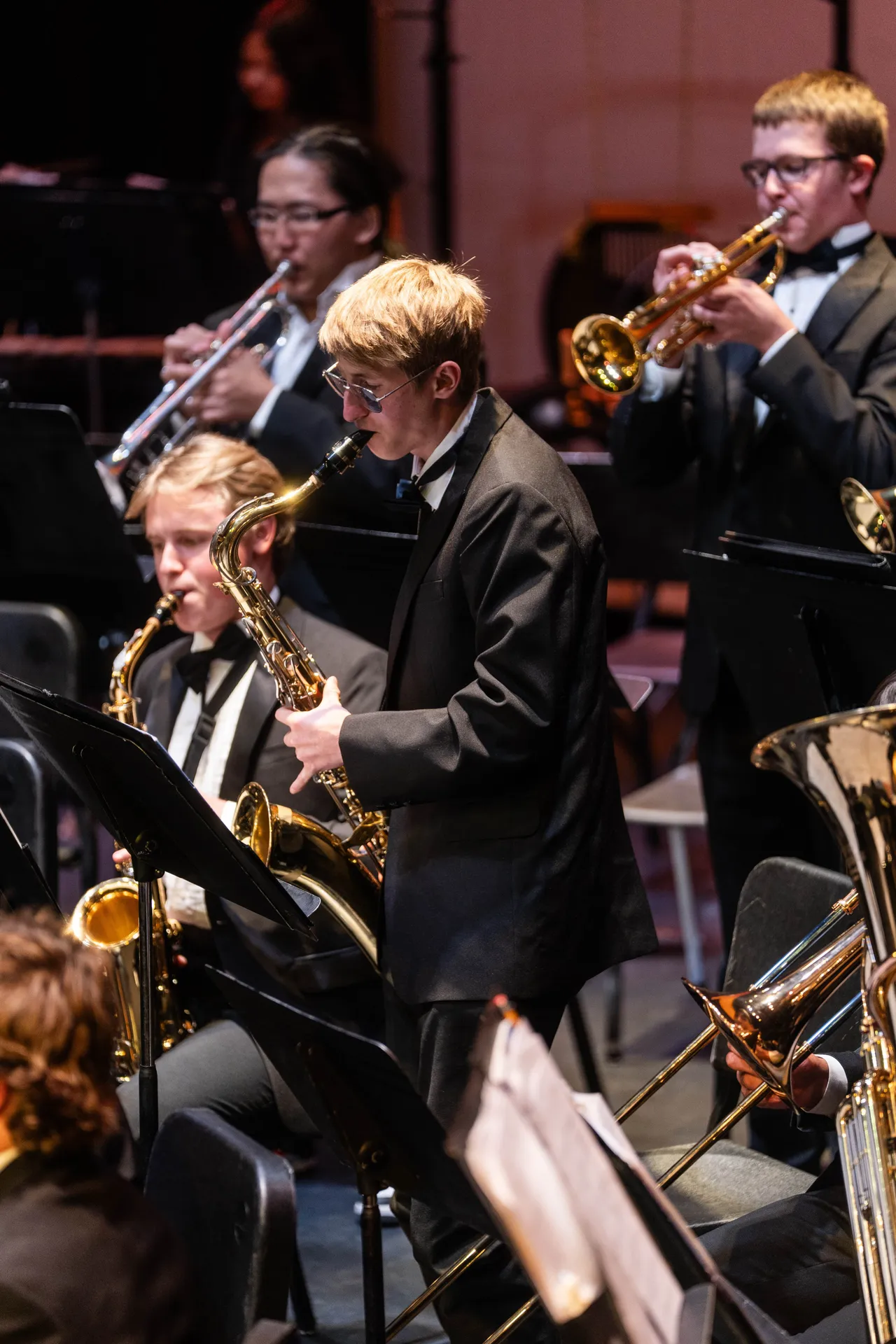 Male high school band students play their instruments during a concert