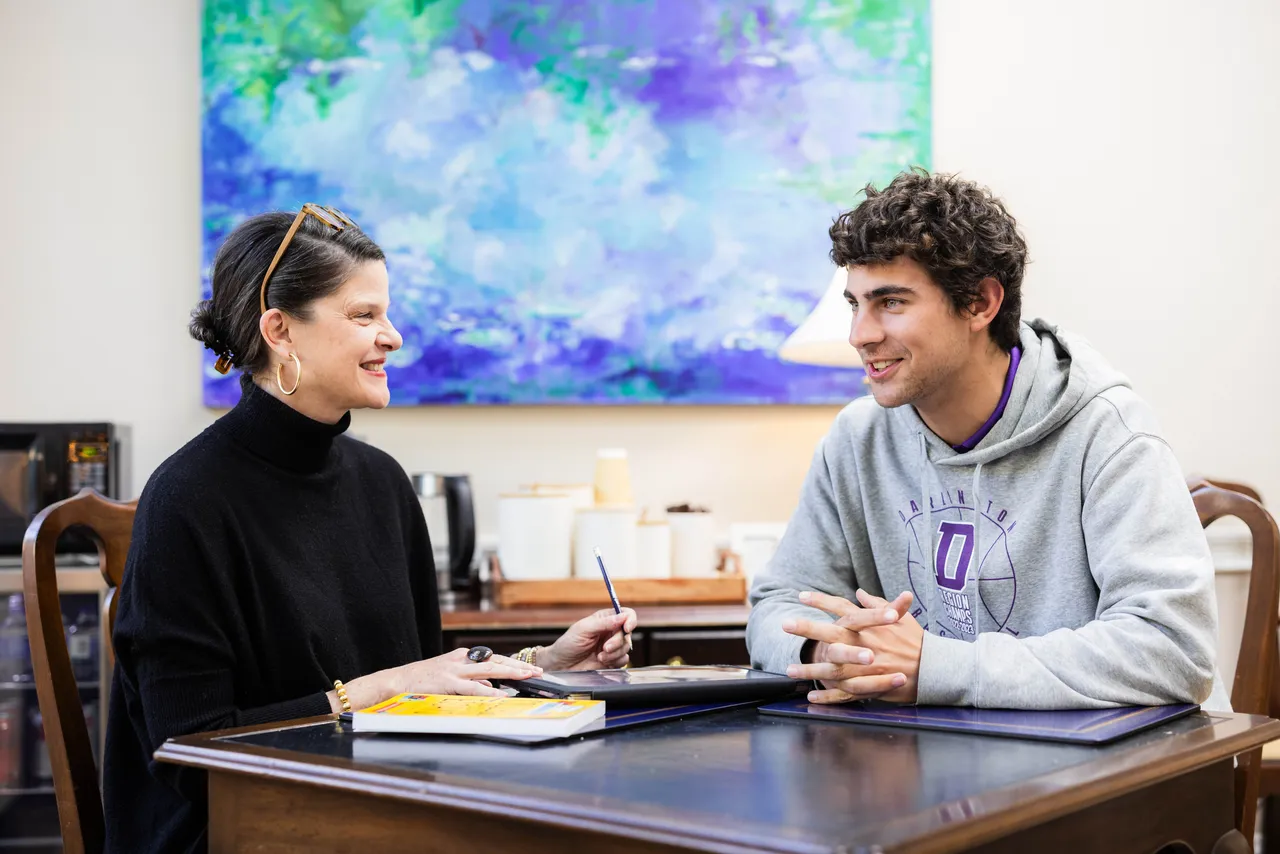 Female college advisor works with male senior to offer college guidance and support