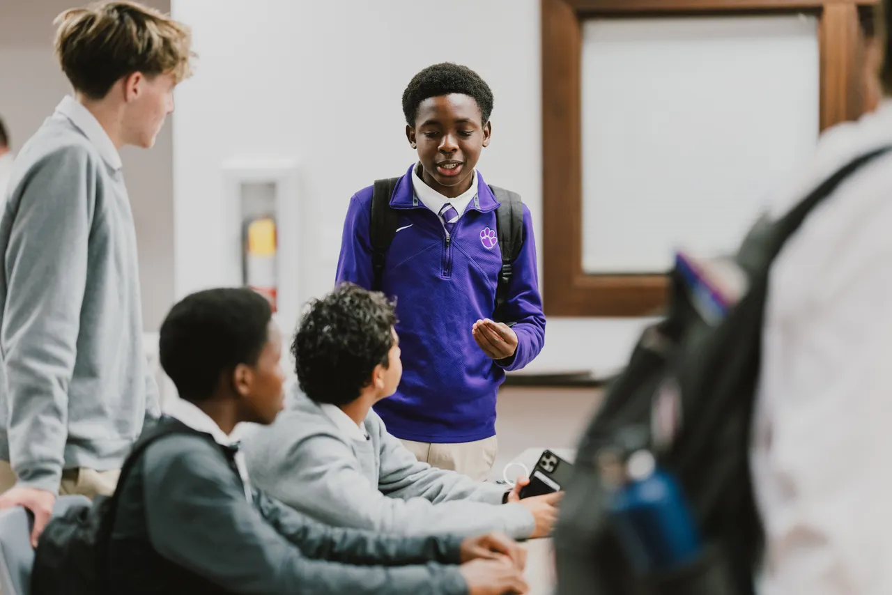 A male student speaks with classmates at Darlington School.