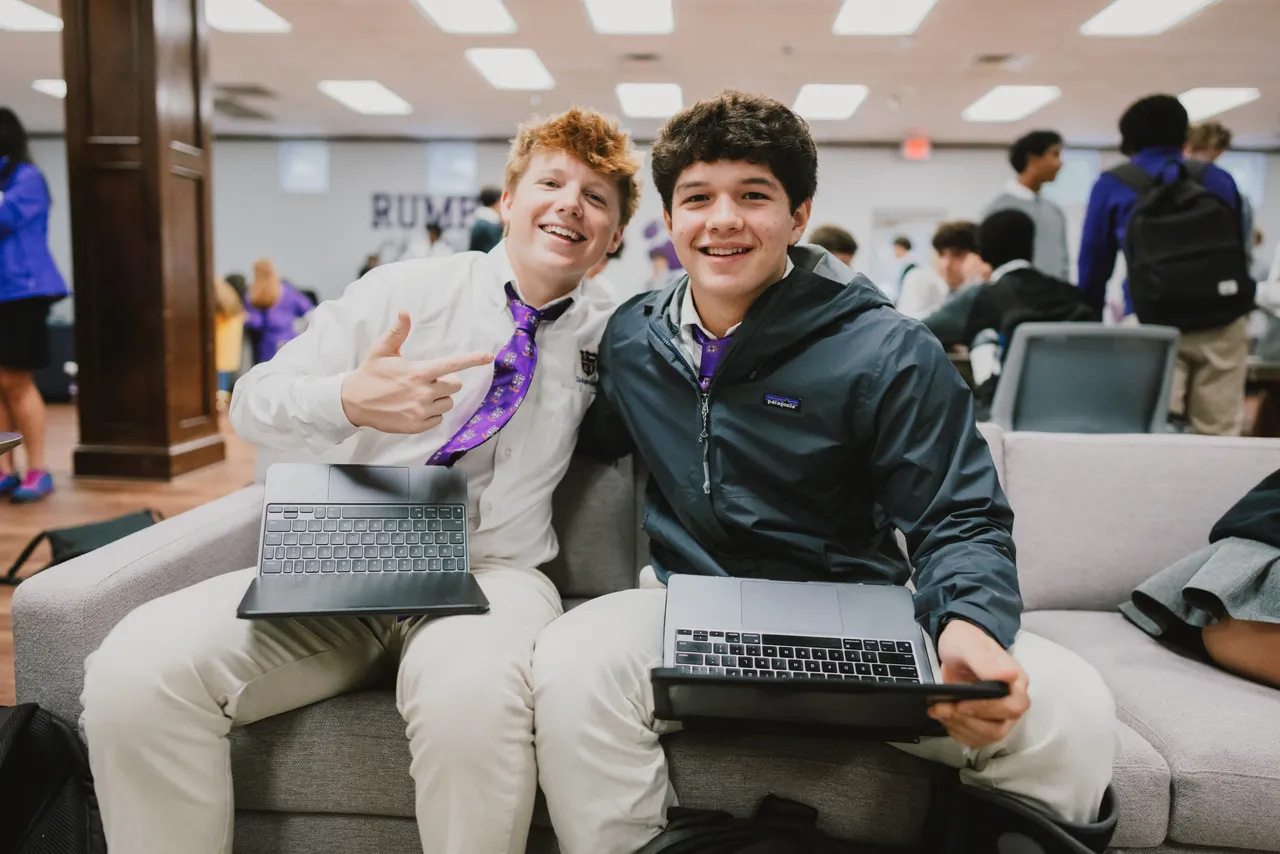 Two high school boys work on their MacBook computers in the student center at Darlington