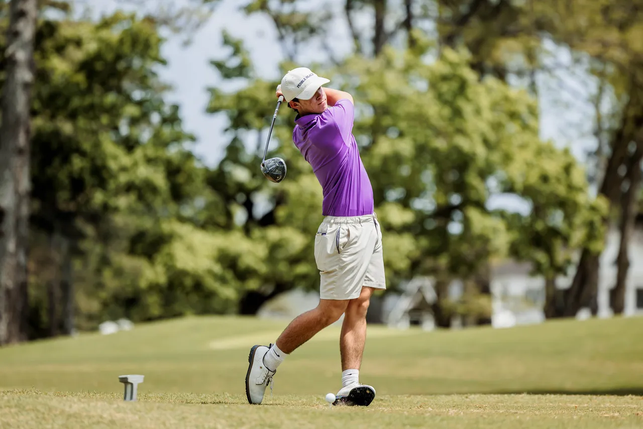 Male golfer swings his golf club on the course