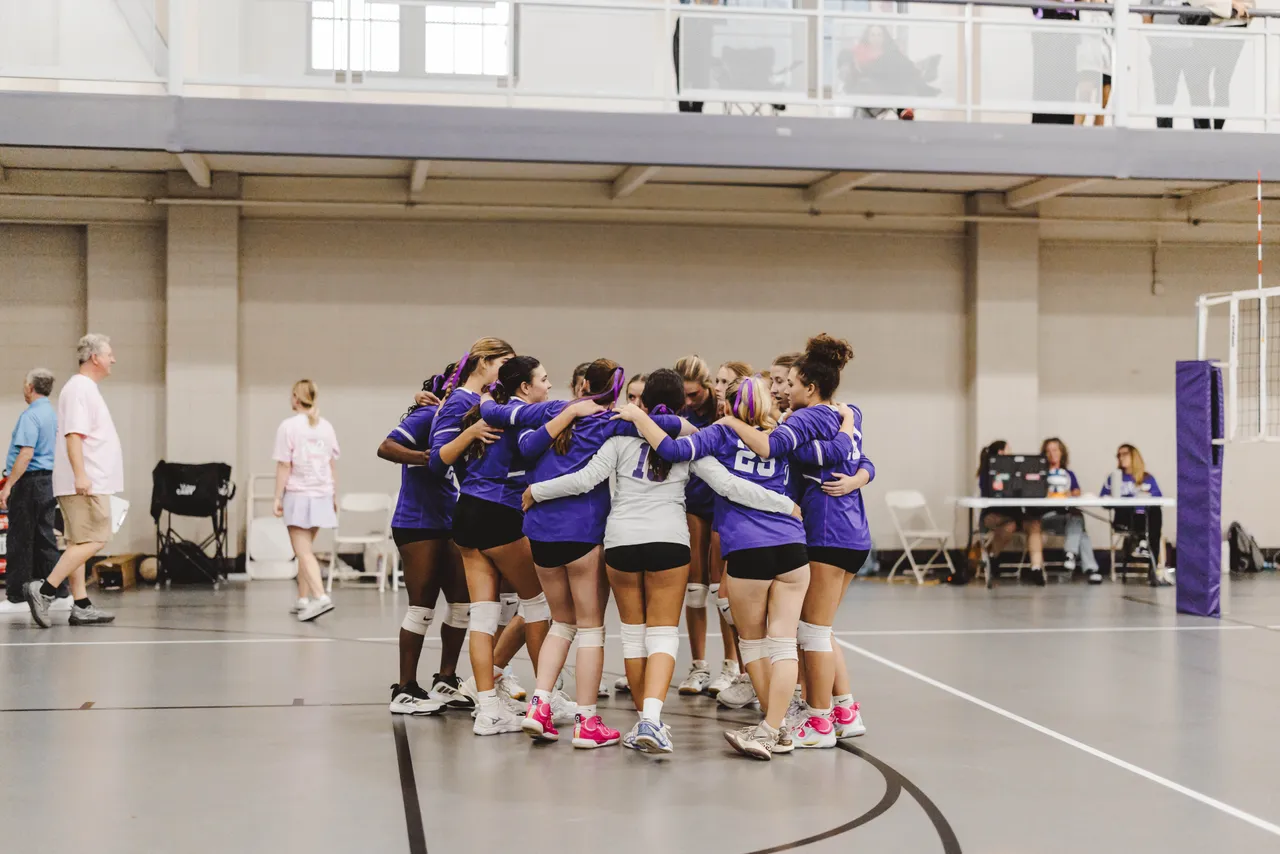 High school volleyball players huddle up during a volleyball match