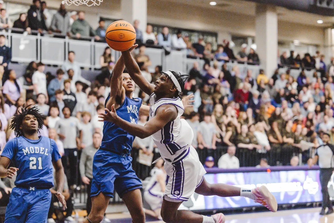 Male high school basketball player jumps up to get the basketball during a game