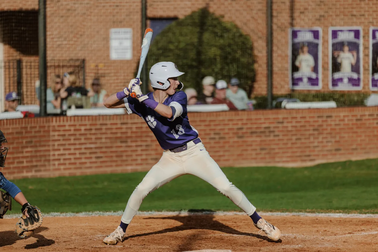 Male high school baseball player steps up to bat during a game