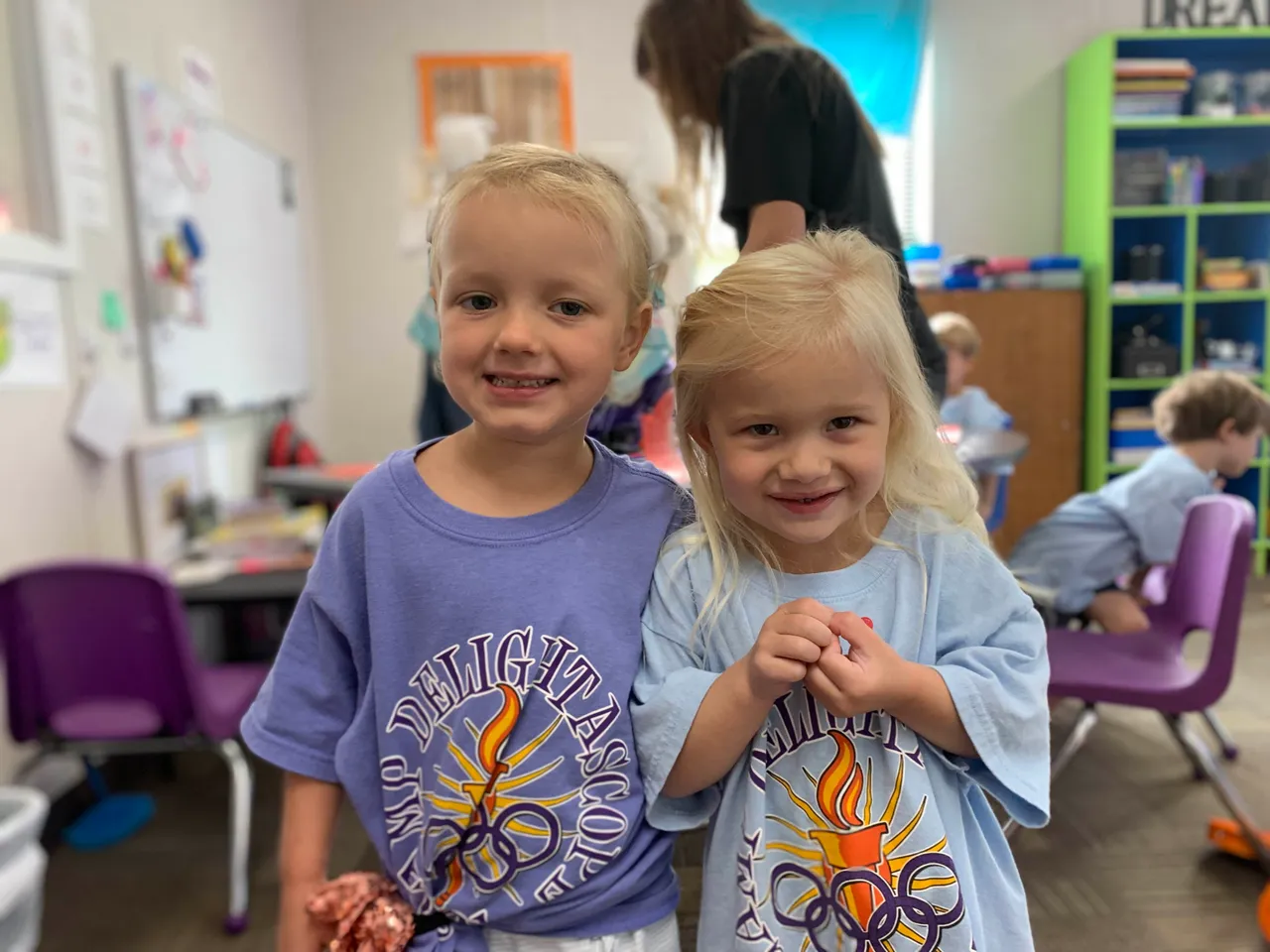 Two young female campers smile together during Camp Delightascope.