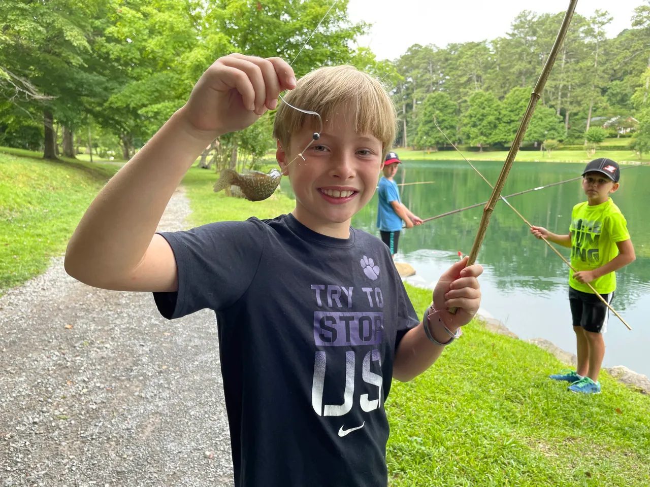 Young male camper shows a fish he caught during Camp Darlington.