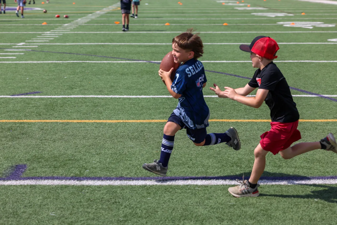 Young male campers participate in a football drill during Darlington School's Youth Football Camp.