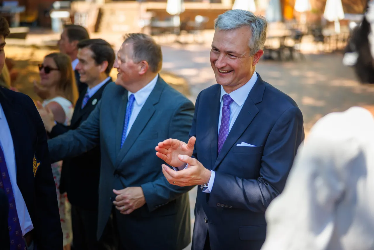Head of school and other faculty members clap for seniors as they recess out after graduation