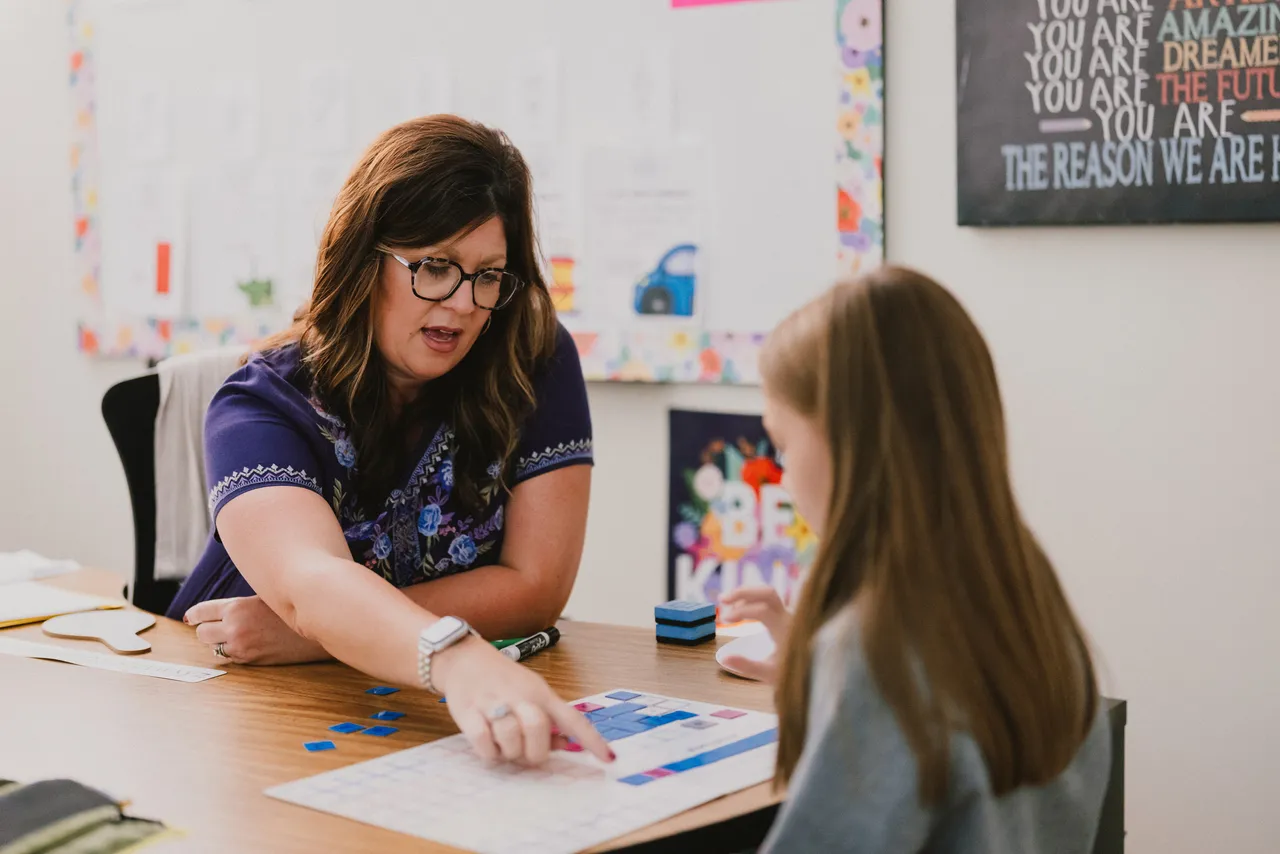 Female learning specialist works with a student in the Teaching and Learning Center doing interactive learning activities