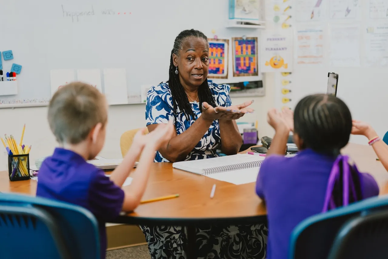 A female learning specialist works with a small group of students on literacy in the Accelerated Learning Program for Dyslexia