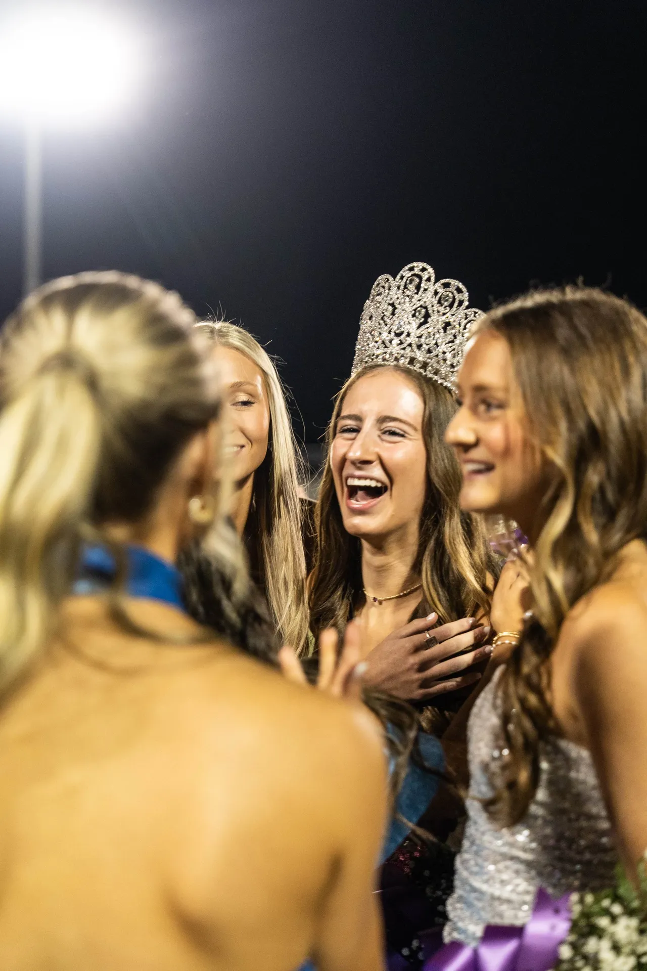 A group of high school girls celebrates after their friend is named Homecoming Queen