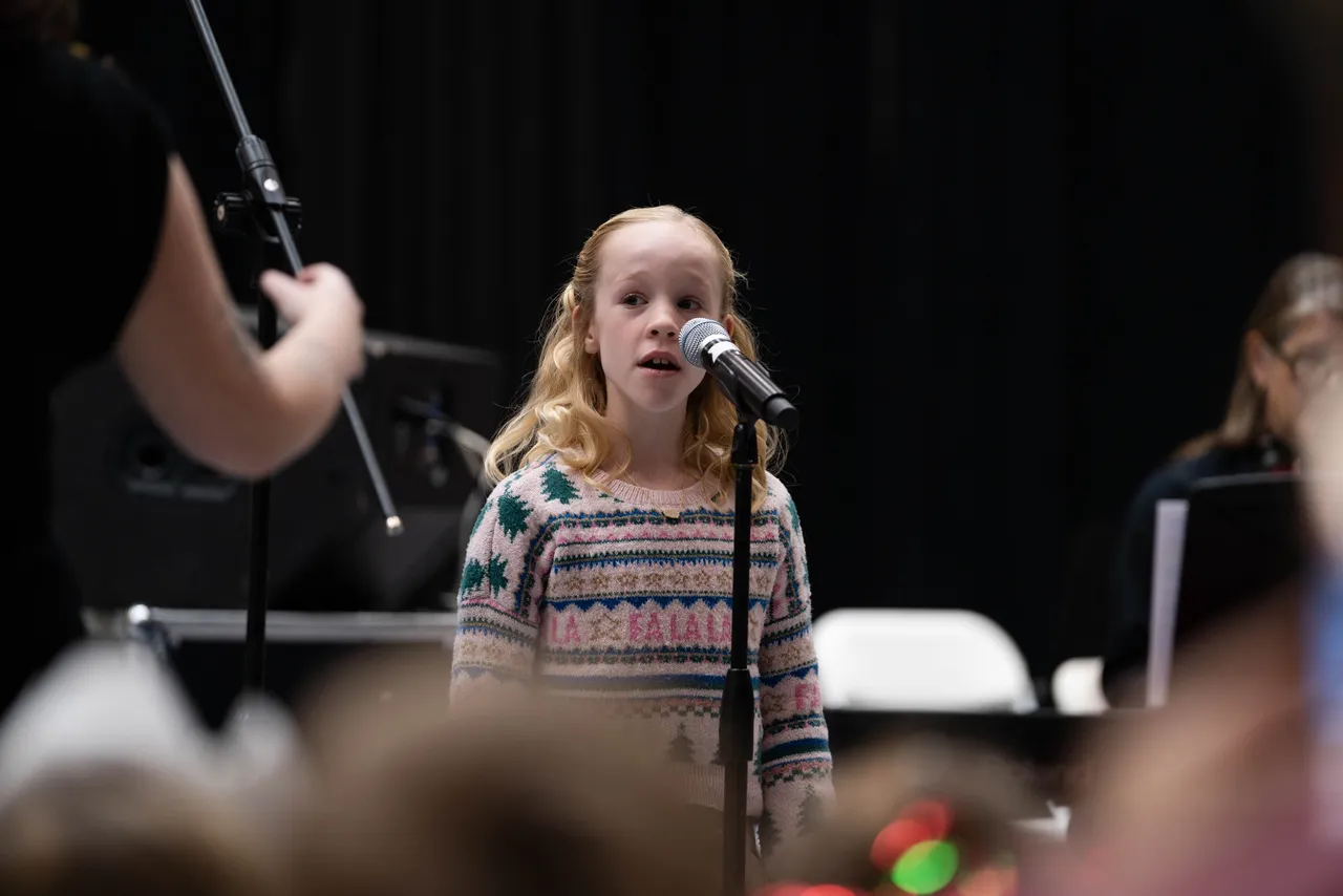 A female lower grades student sings a solo during a concert