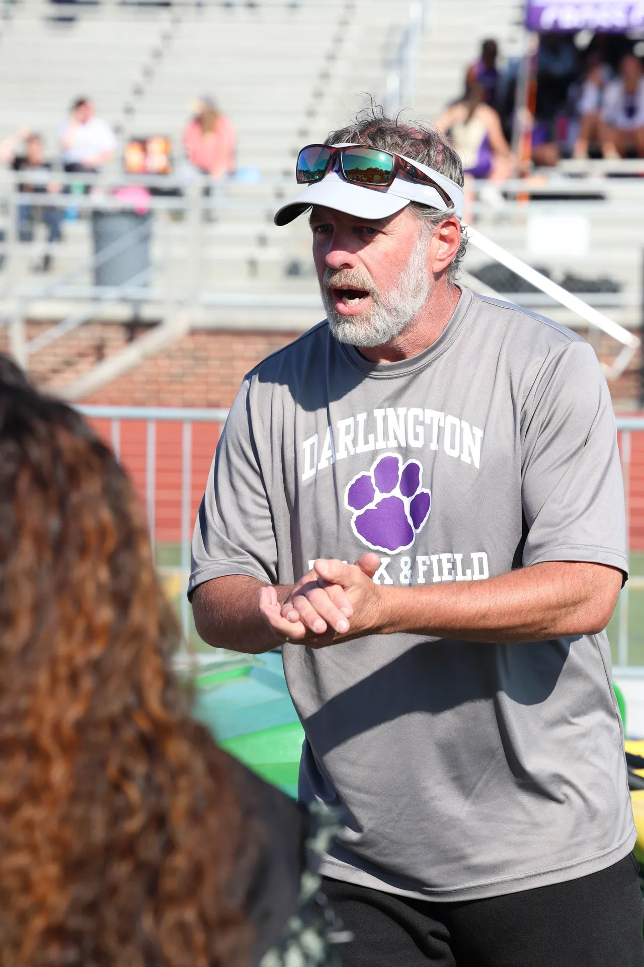 Male faculty member coaches track and field student-athletes.