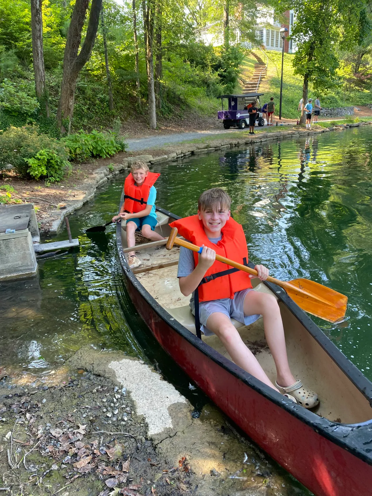 Two male campers paddle a canoe on Silver Lake during Camp Darlington.
