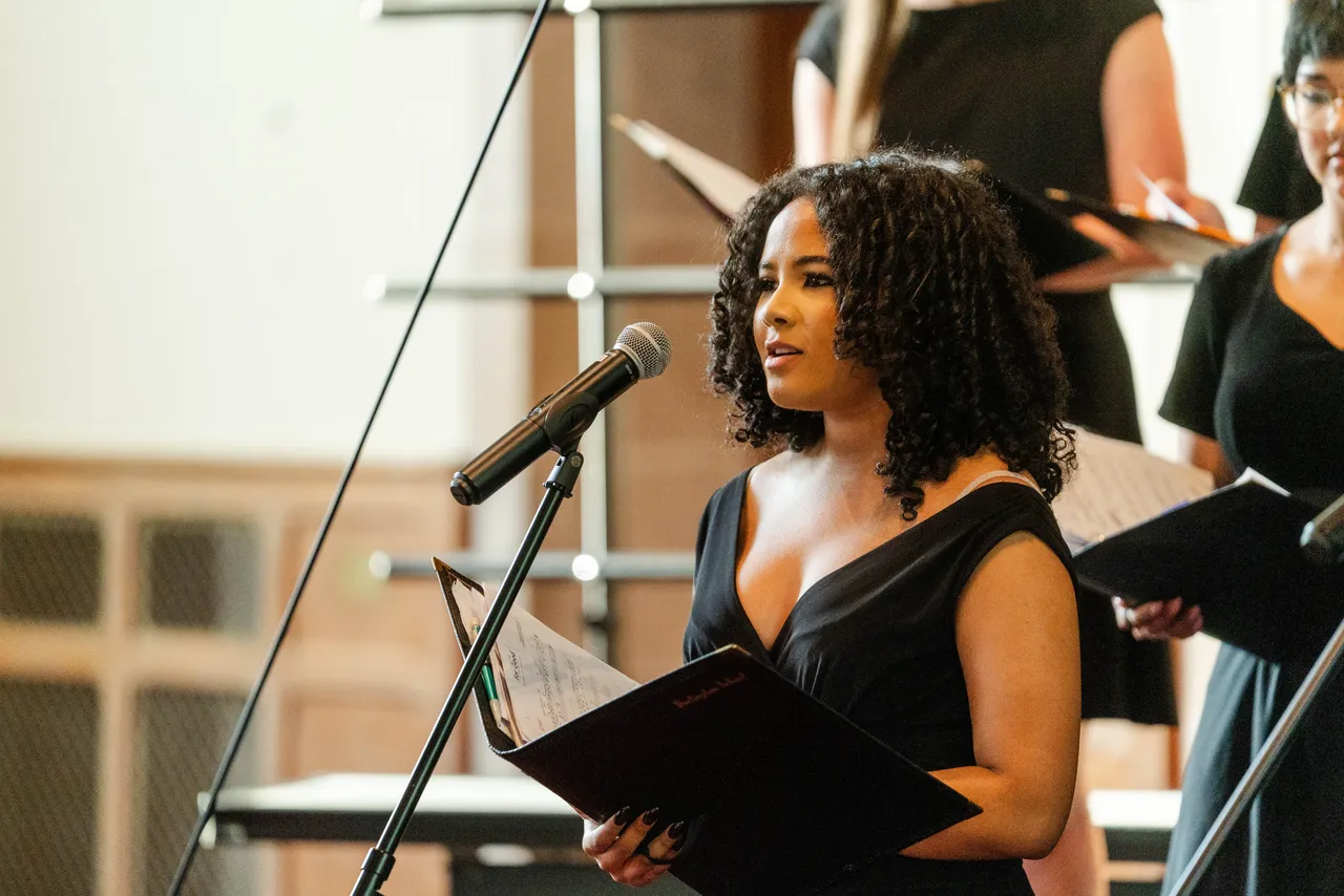 A female high school student sings during a choir concert in the chapel