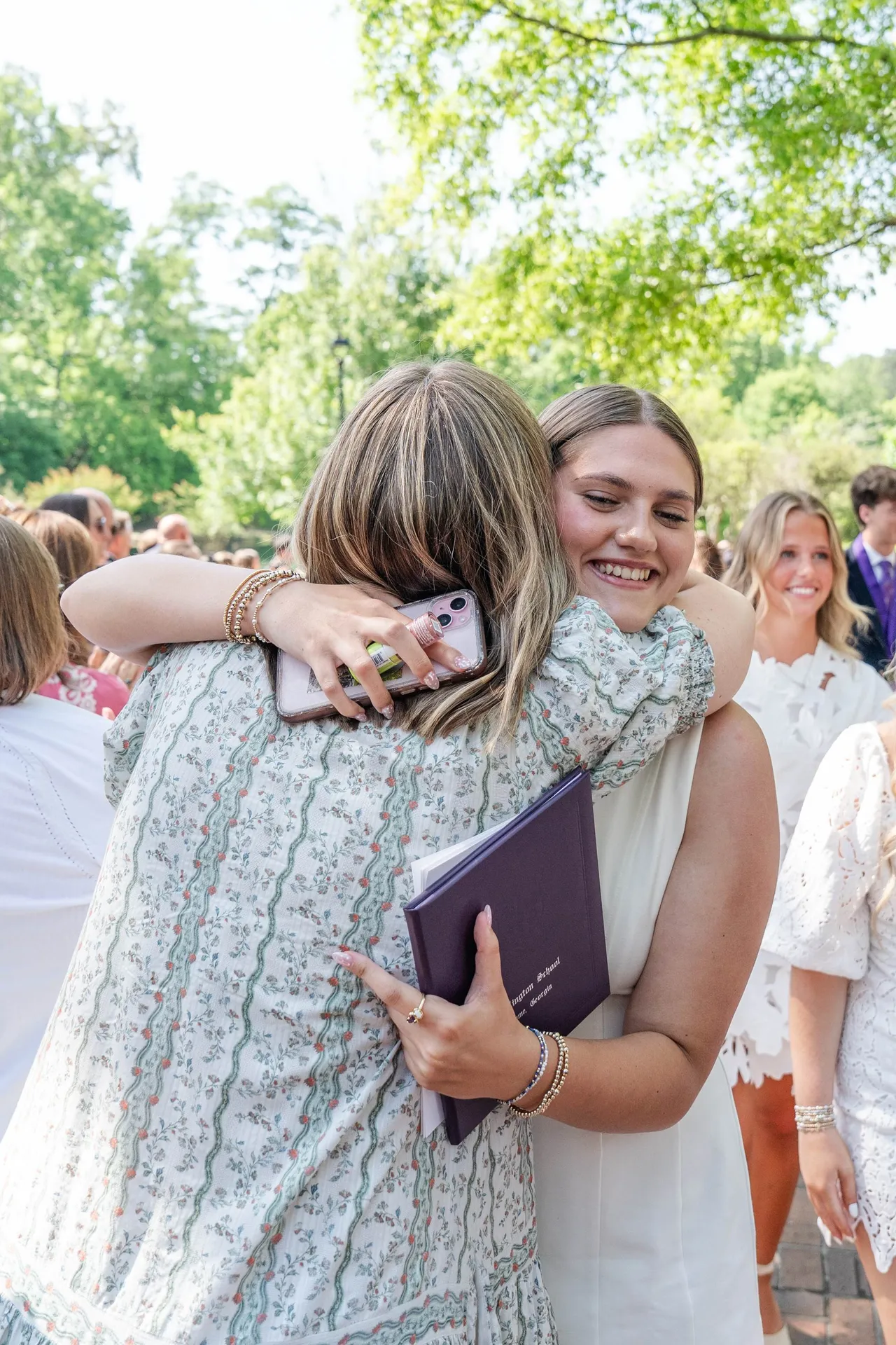 A female faculty member hugs a female student after her graduation from Darlington School