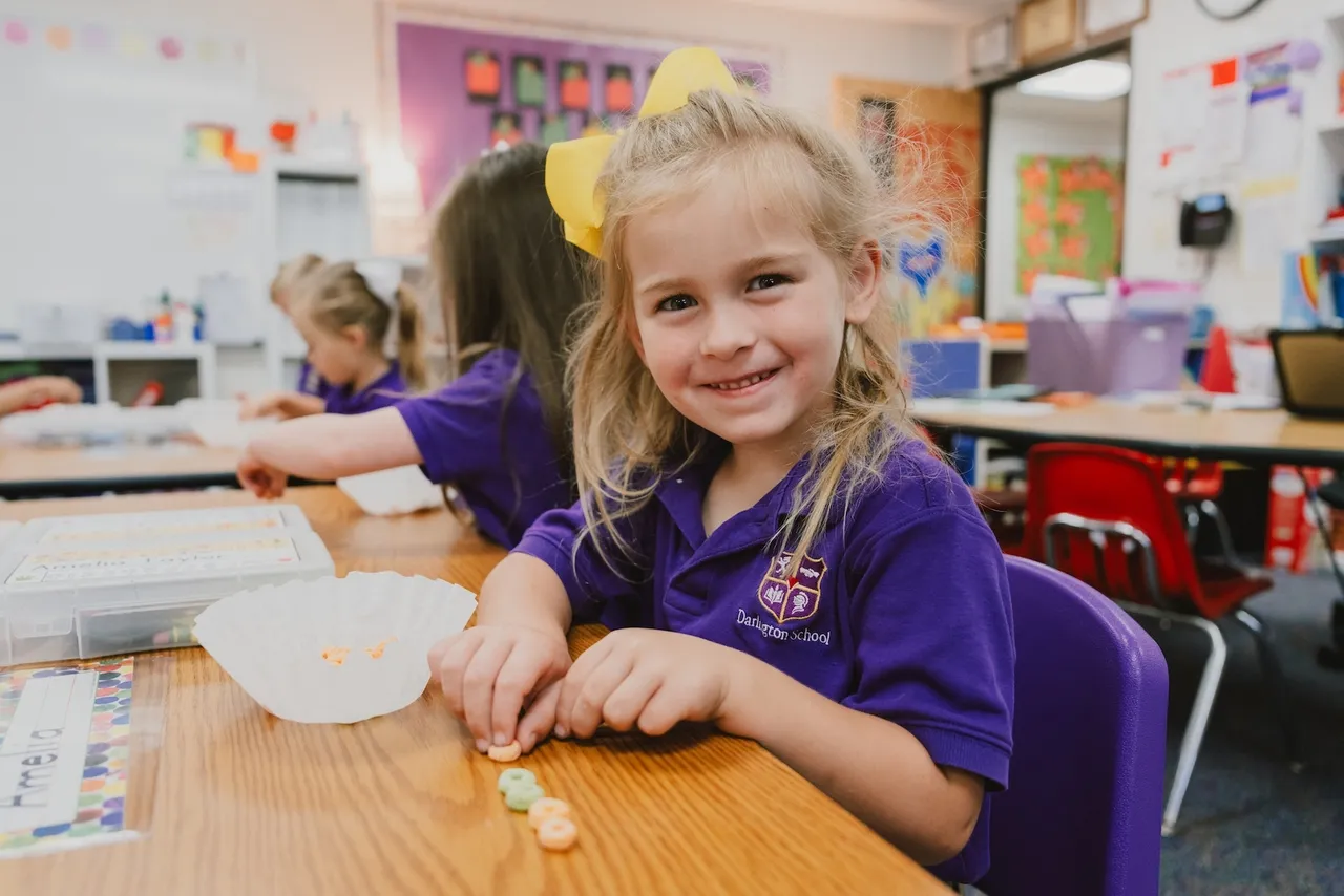 Female primary grades student does a counting activity in her pre-K classroom