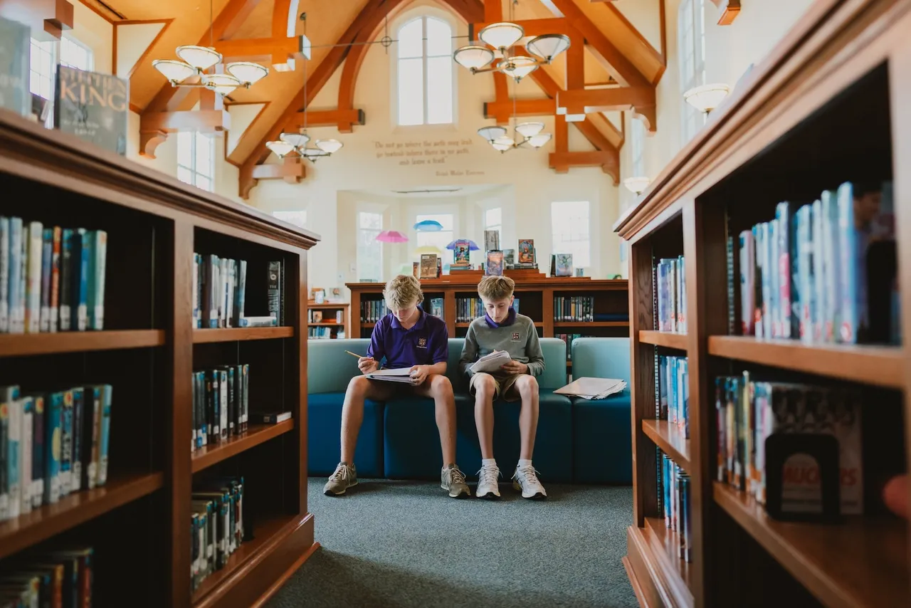 Two male middle school students work together in the library