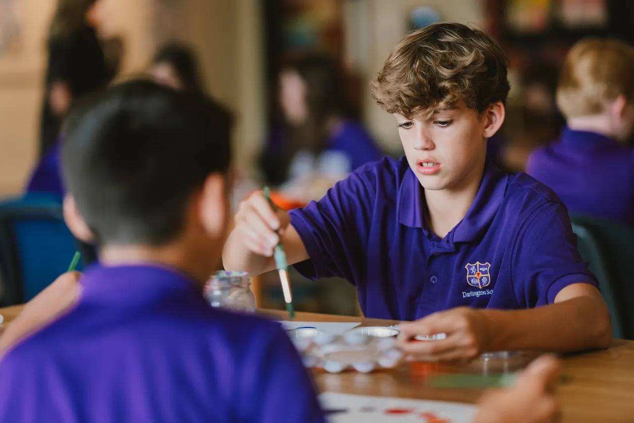 Middle school boys paint in art class