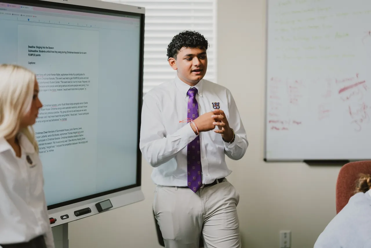 Male high school student gives a presentation in class