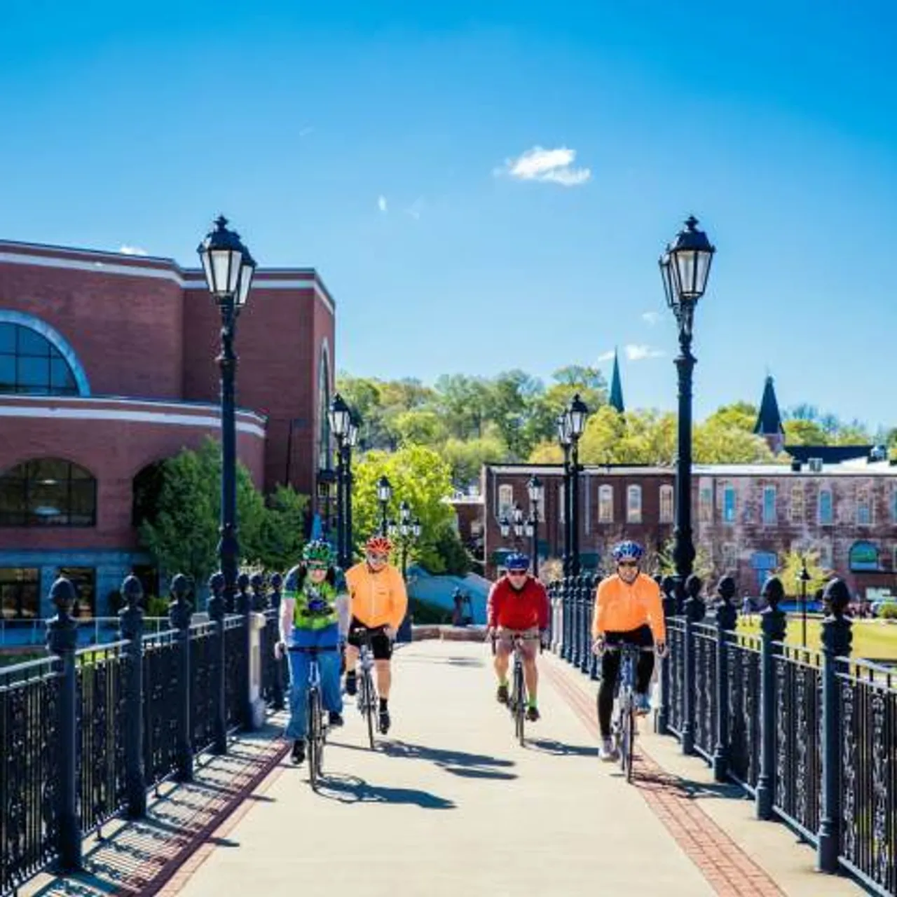 Four people bike across a bridge in Downtown Rome, GA