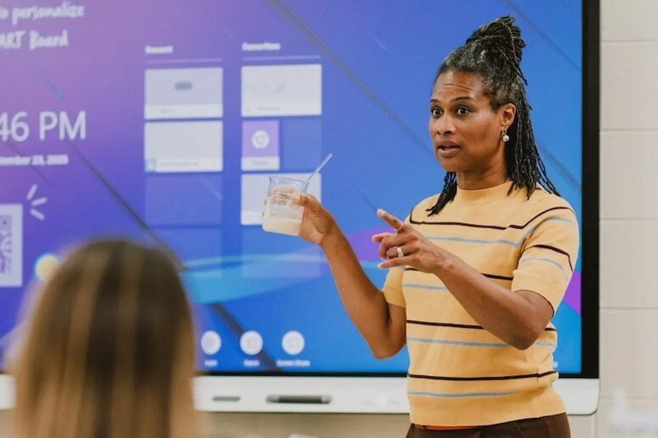 Female faculty members teaches science in front of a SMART Board