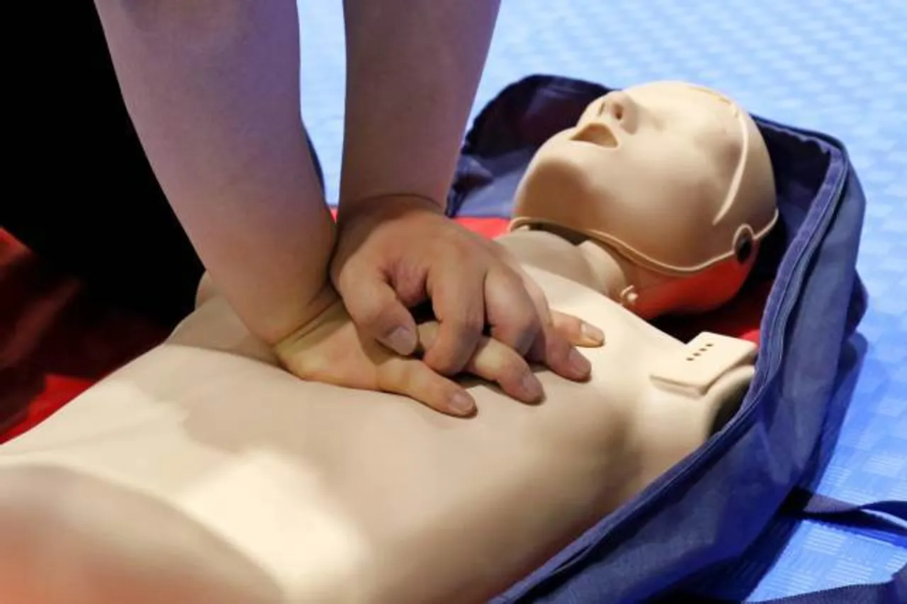 Faculty member does CPR training on a mannequin