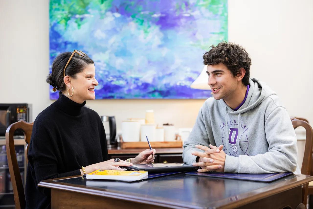A female college counselor works one on one with a senior to provide college guidance and support